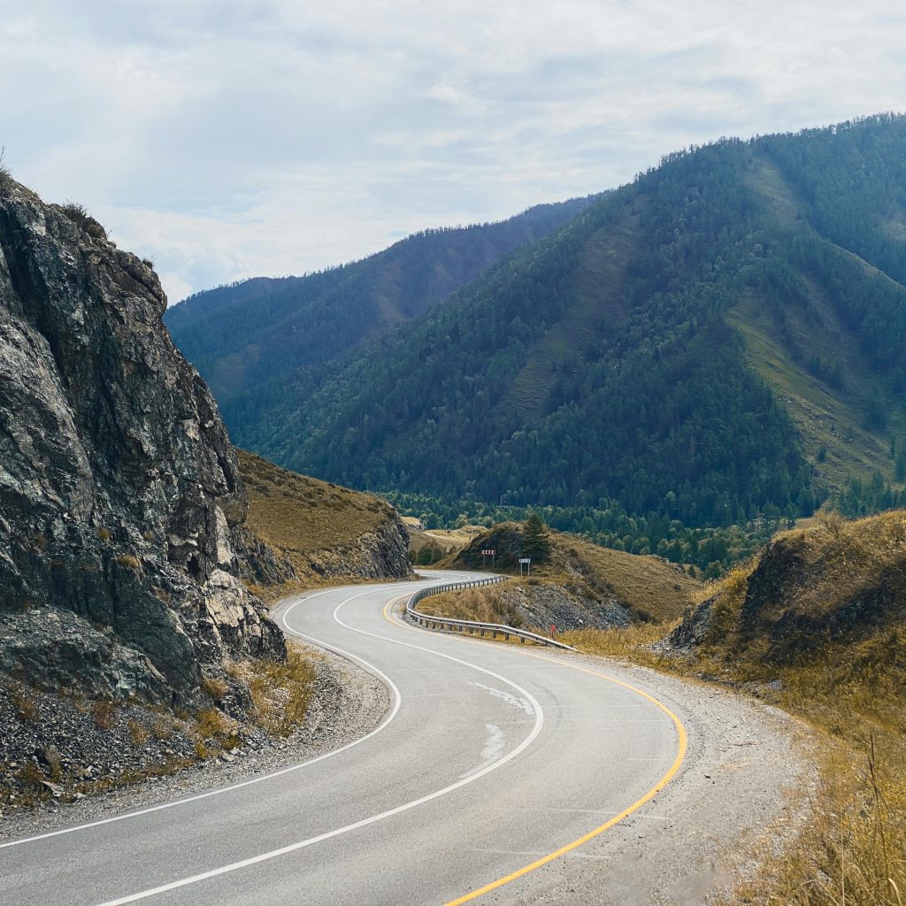 Winding road through picturesque mountains in Altai, Russia, offering a scenic travel route.
