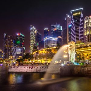Dazzling view of the Singapore cityscape with Merlion and illuminated skyscrapers at night.